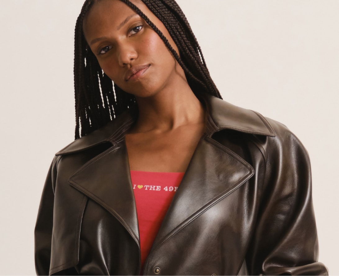 Woman in a brown leather jacket over a red 49ers tee