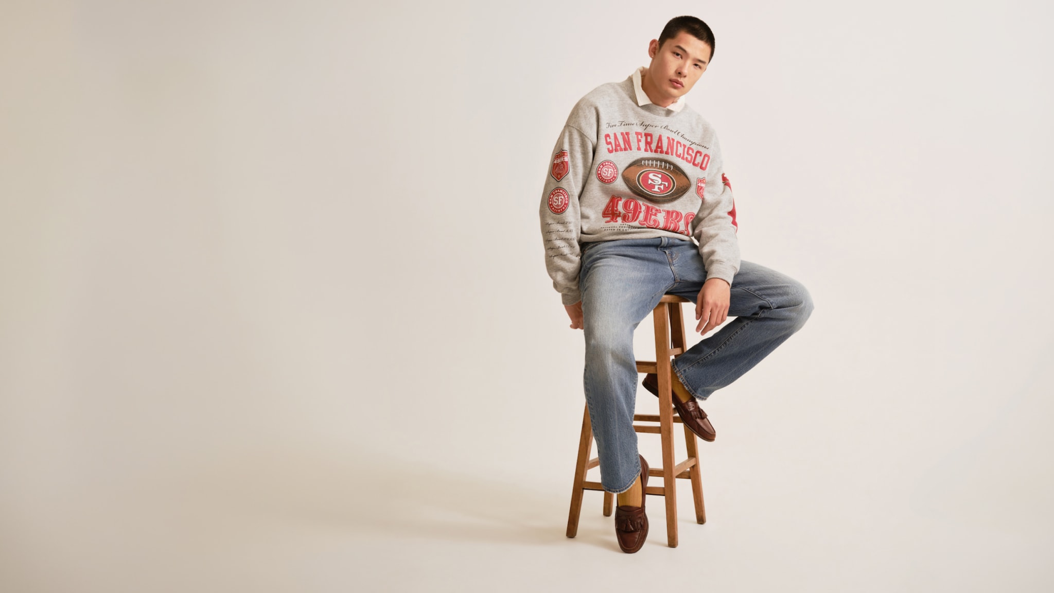 Man wearing a San Francisco 49ers graphic sweatshirt with jeans