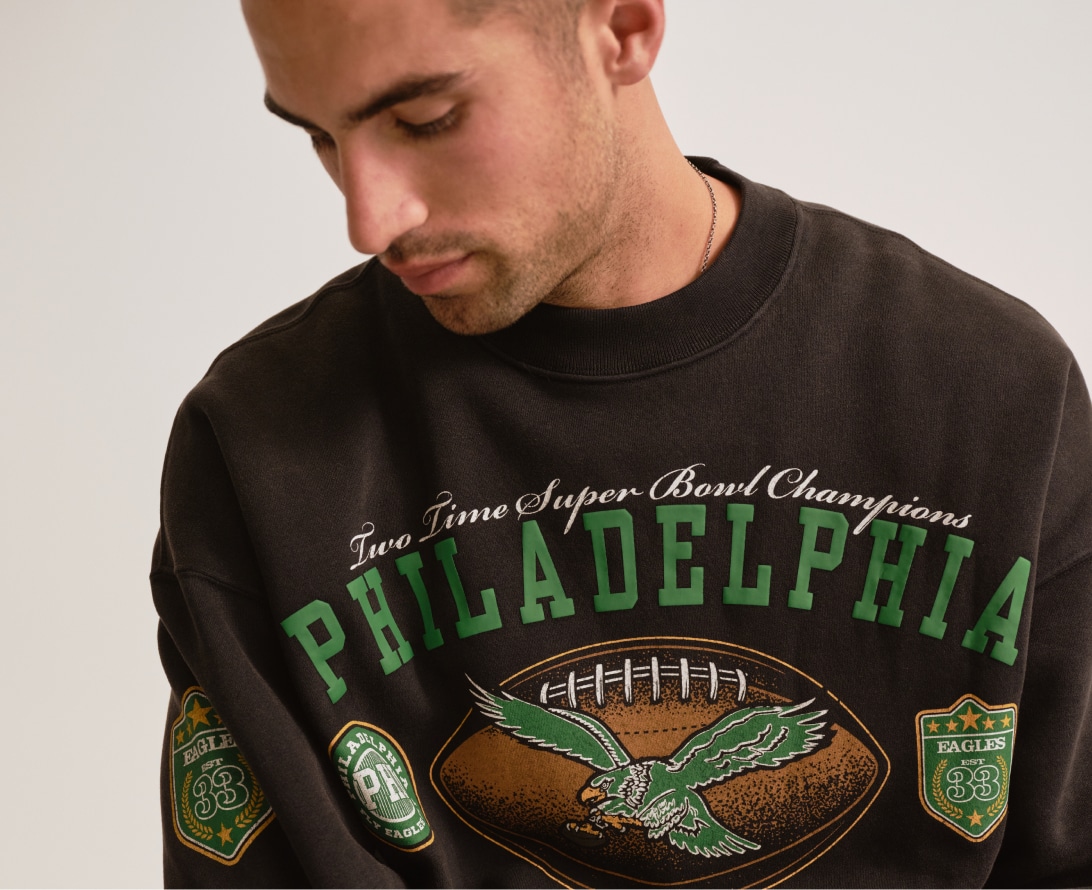 Man in a washed black Philadelphia Eagles graphic sweatshirt